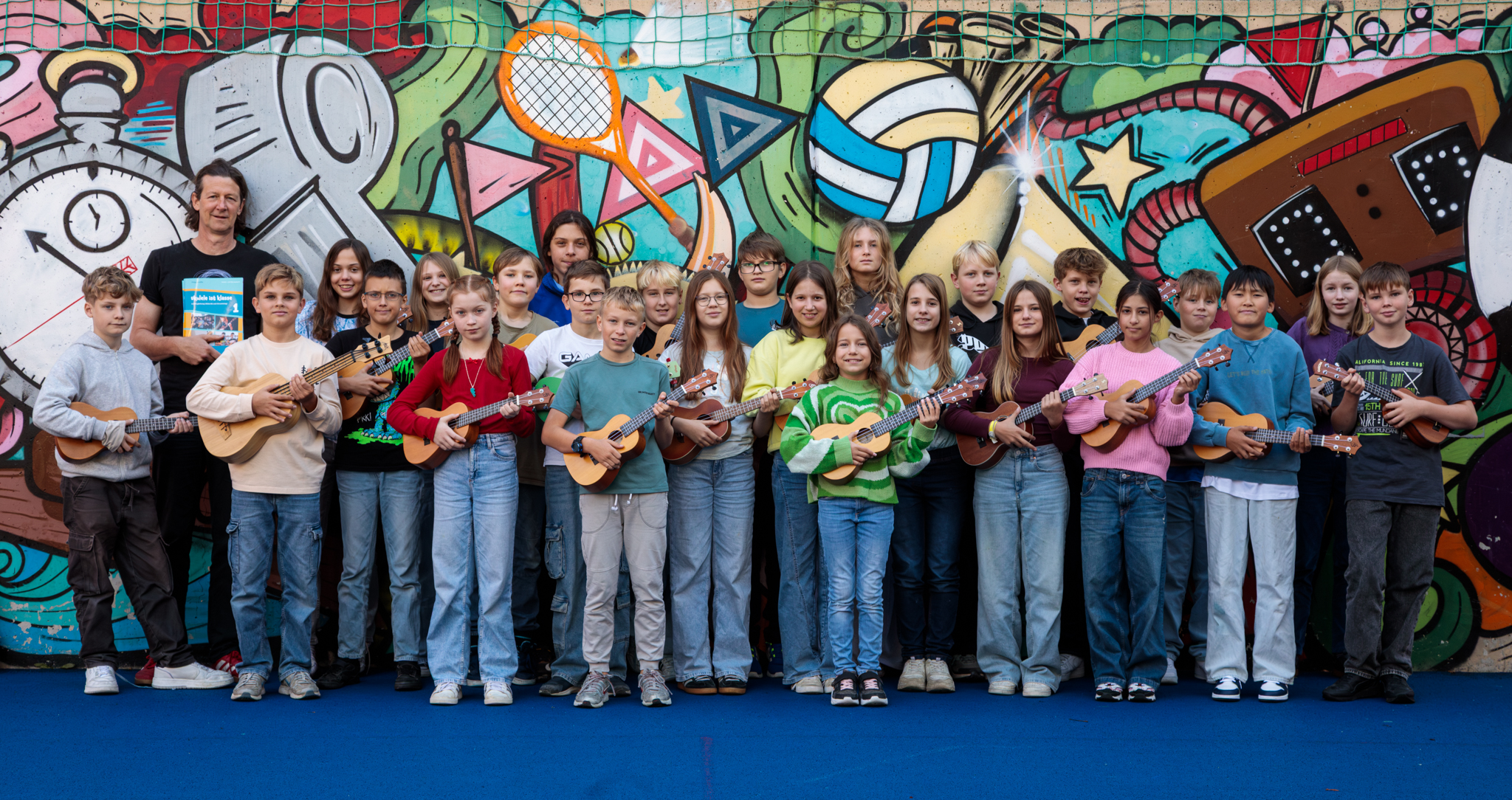 Ukuleleklasse vor Graffiti-Wand