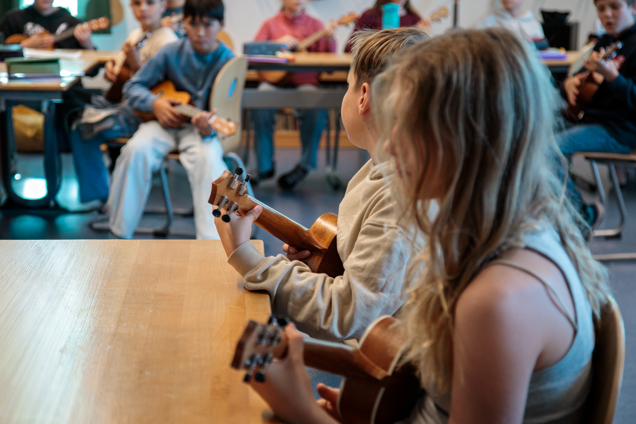 Schüler spielen Ukulele im Klassenraum